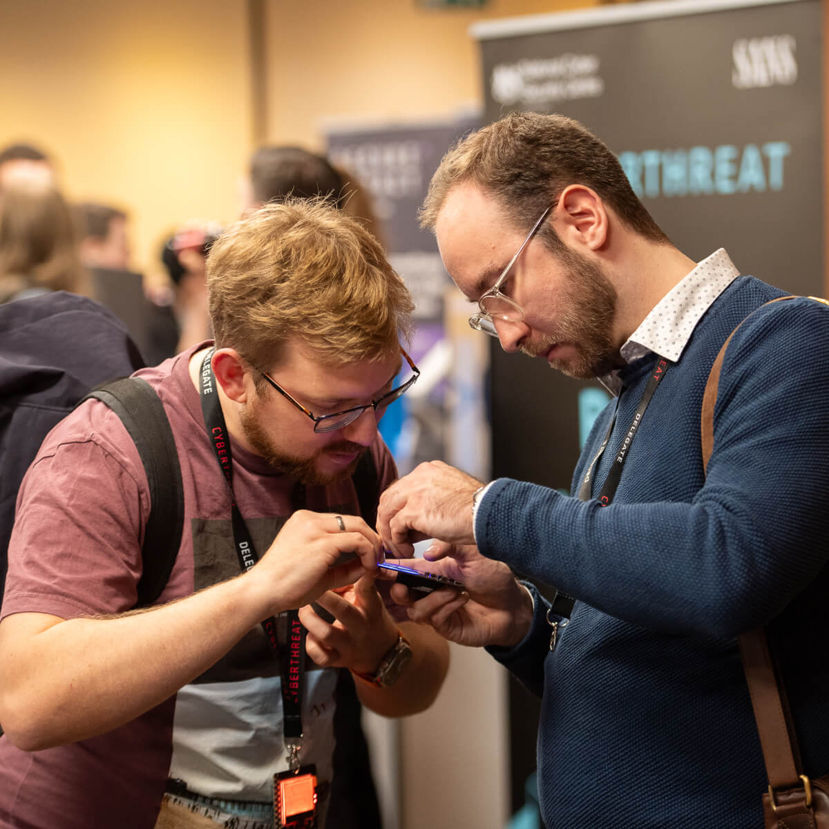 Attendees at CyberThreat 2023 playing with the hackable badge